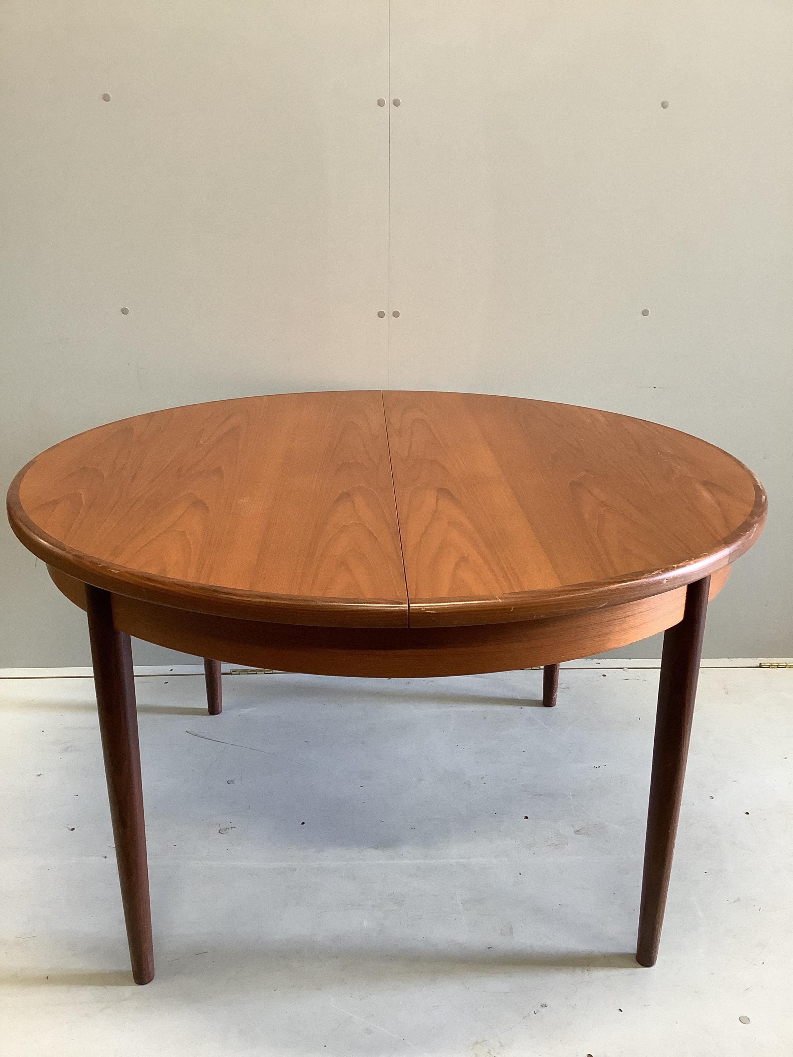 A mid century G Plan teak circular extending dining table, diameter 122cm, four chairs and sideboard, width 138cm, depth 44cm, height 72cm and a nest of tables. Condition - fair